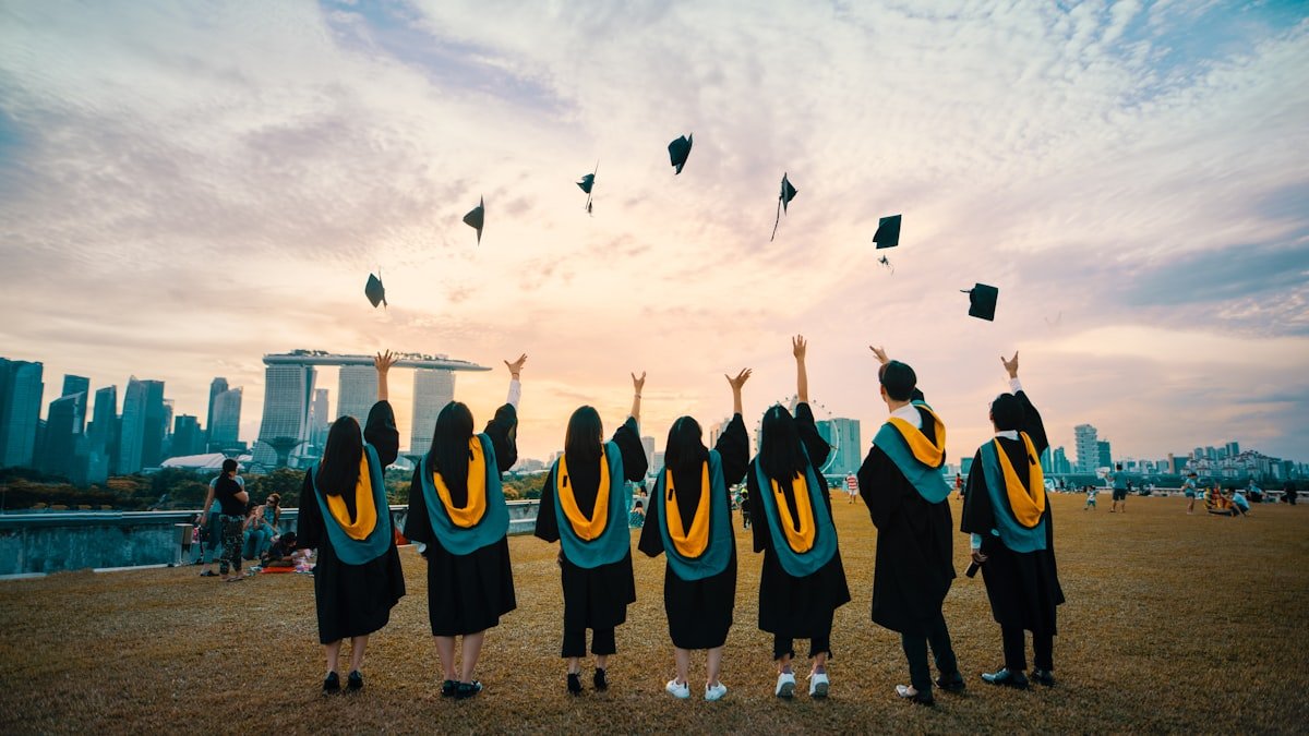 College graduate holding diploma next to laptop representing affordable online degree