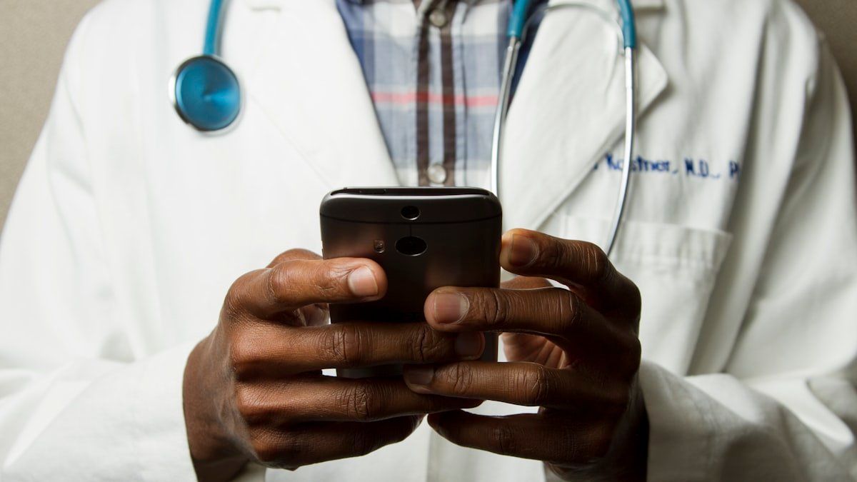 Doctor reviewing medical healthcare insurance coverage policy options with young adult patient