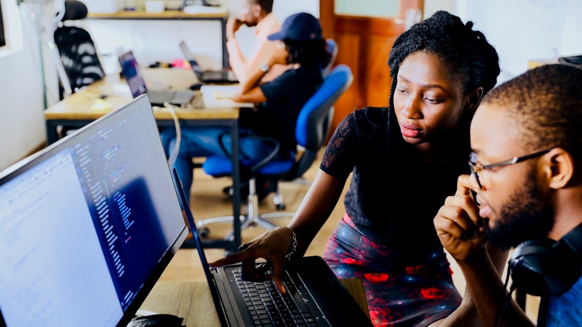 Working student taking online associate degree courses on tablet in modern workspace
